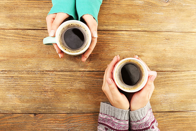 female hands holding cups of coffee